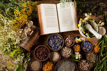 Book and Herbal medicine on wooden table background
