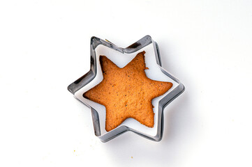 Star-shaped cookie cutter and freshly baked gingerbread, isolated, copy space, closeup
