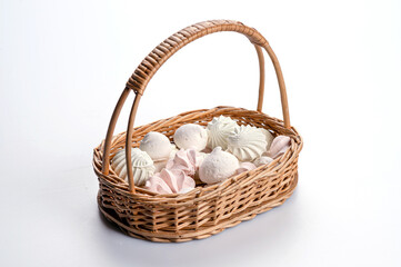wicker basket with meringue cookies from egg whites, selective focus, closeup, isolated, copy space