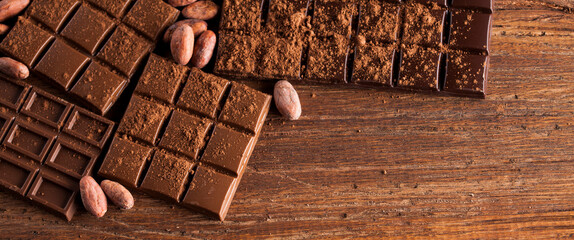 Dark homemade chocolate bars and cocoa pod on wooden
