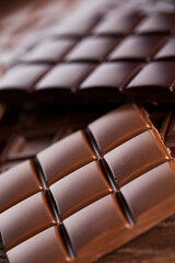 Dark homemade chocolate bars and cocoa pod on wooden