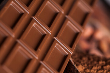 Chocolate bar, candy sweet, cacao beans and powder on wooden background