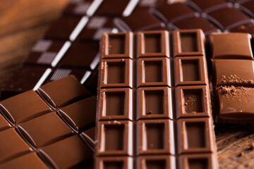 Dark homemade chocolate bars and cocoa pod on wooden