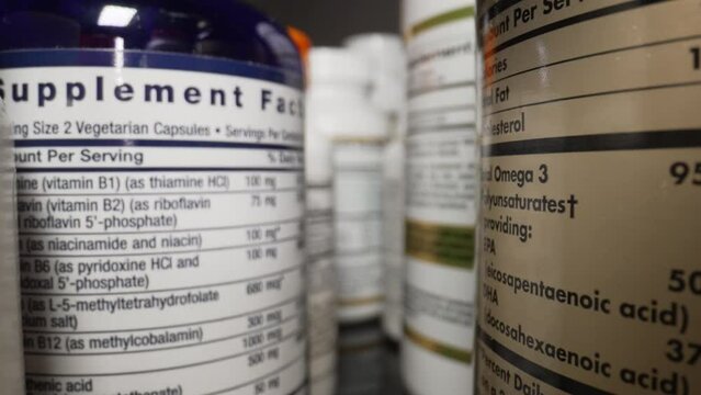 Plastic Cans for Tablets, Fish oil, Omega 3 or D-3 pills. The Camera Moves Through Many Containers of Dietary Supplements Pills for a Healthy Lifestyle. Pharmaceutical Industry