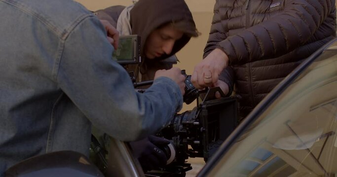 The film crew prepares the camera for use. The actor is in the car. Replacing an element. Back stage movie scenes. Glare and reflections on glass. CZ, Prague, Myslikova, 23.2.2022