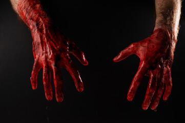 Male bloody hands on a black background.  - obrazy, fototapety, plakaty