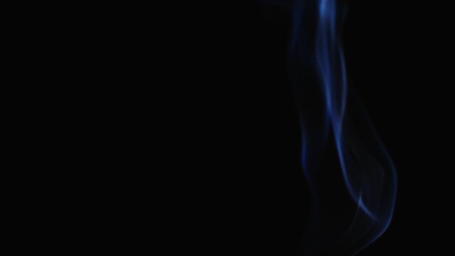 Realistic cloud smoke with a streamlined pattern. Abstract blue smoke on dark background in slow motion.