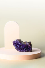 Purple rough Amethyst mineral  on beige platform. Modern gem stone baclground.
