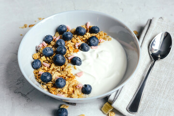 Yogurt with muesli and berries on a gray background.