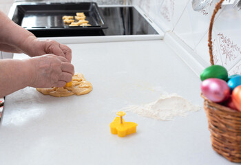 Senior woman hands cut out from dough pastry cookies for Easter day. Happy Easter concept. Process of making cookies. Cooking at home concept. Tradition home-made food