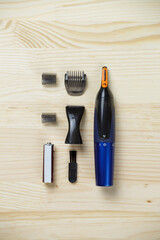 trimmer for nose, ears, eyebrows. Set for eyebrows, nose and ears. Personal care. Flat lay on a wooden background.