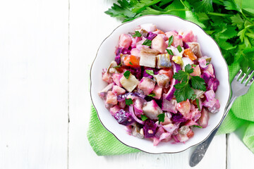 Salad with herring and beetroot in bowl on napkin top