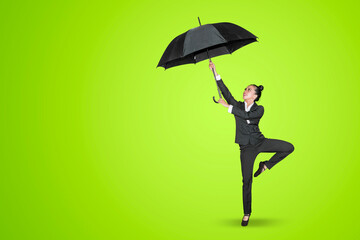 Businesswoman hold umbrella while dance on studio
