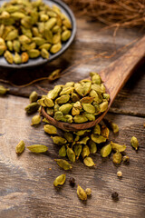 Cardamom spice seeds on the wooden background