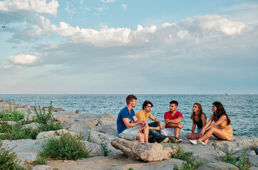 group of young people at sunset at the beach