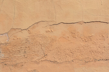 material texture of terracotta painted plastered wall with imperfections and cracks