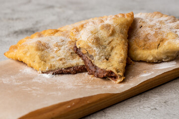 Uzbek eastern Tatar cuisine, sweet cheburek on a wooden board. Cheburek - fried pie with chocolate.