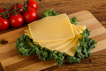 Sliced Gauda cheese over board