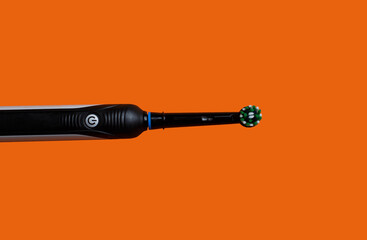 Closeup of Electric toothbrush isolated on orange backrgound
