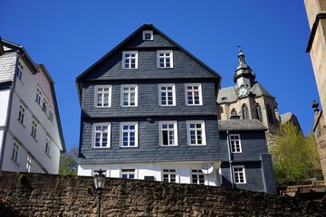 Schöne alter Schieferfassade in Anthrazit mit Spitzgiebel  und das Marburger Schloss vor blauem...