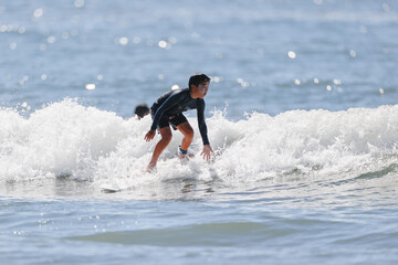 湘南の海でサーフィンをする少年