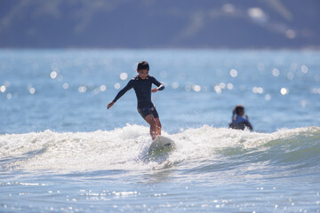 湘南の海でサーフィンをする少年