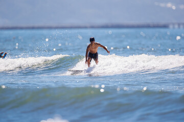 湘南の海でサーフィンをする男性