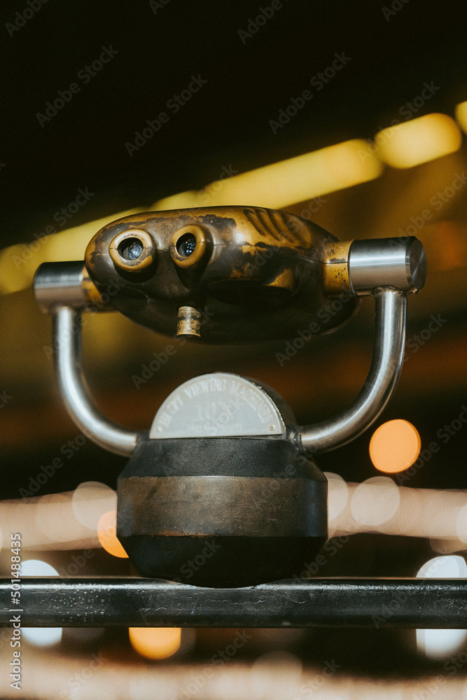 Poster closeup shot of installed sightseeing binoculars and bokeh background