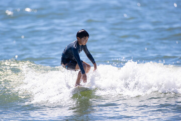 湘南の海でサーフィンをする少年