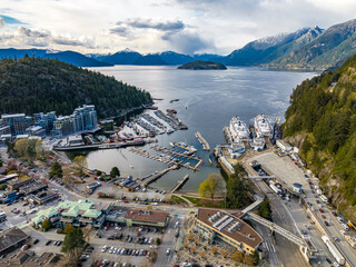 Aerial shot of the city, dense forest and moored boats at the harbor of Horseshoe Bay, BC, Canada