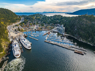 Aerial shot of the city, dense forest and moored boats and ferries at the harbor of Horseshoe Bay