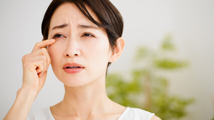 目を掻く若い女性