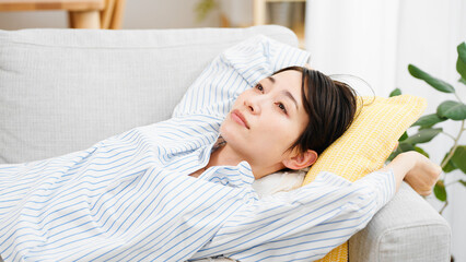 ソファーで昼寝をする若い女性