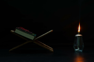 Quran-Lamp, black background, placed on a wooden board, Muslim Quran book around the world