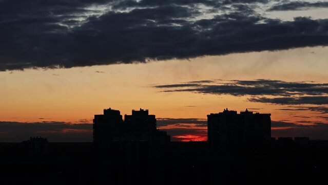 sunset sky against the background of tall residential urban buildings. roofs of houses on the background of clouds