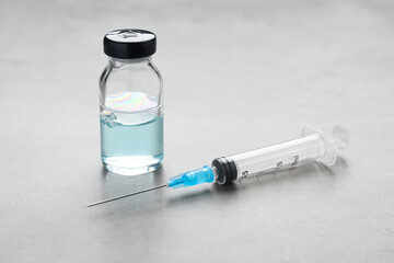 Syringe and vial on grey table. Medical anesthesia - obrazy, fototapety, plakaty