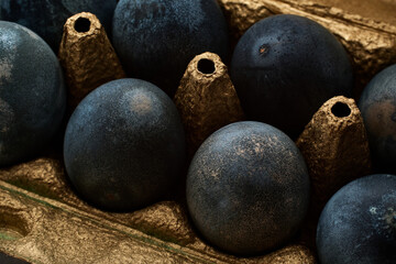 gray eggs lie in a golden box on a concrete