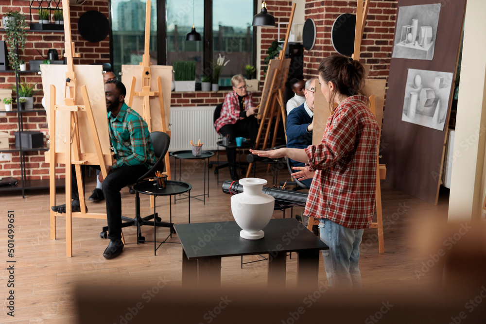 Poster painter teacher showing model for drawing course explaining illustration technique during art lesson