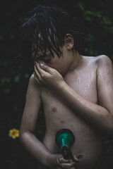 mokry chłopiec, latem ze szlauchem ogrodowym w ręku