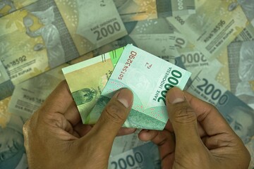 Dua puluh ribu rupiah, translate 20000 IDR, Indonesia rupiah money concept was helad by businessman...