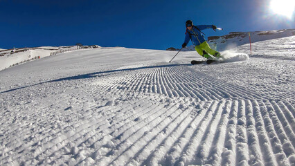 A skier going down the slope in Heiligenblut, Austria. Perfectly groomed slopes. High mountains...