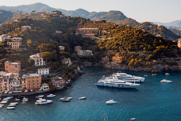 Liguria, Italy, Europe. Luxury yachts and boats in The beautiful Portofino with colorful houses and villas,  in little bay harbor. - obrazy, fototapety, plakaty