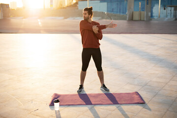 Fitness training outdoors. Handsome man working exercises in early morning. Muscular man training outside..