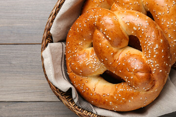 Basket with delicious pretzels on wooden table, closeup
