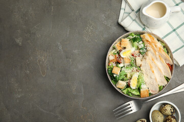 Delicious Caesar salad in bowl on grey table, flat lay. Space for text