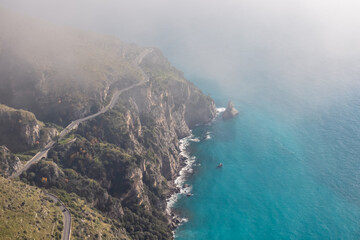 Aerial view from a hiking trail on the coastal driving road of the beautiful scenic Amalfi Coast, Campania, Italy, Europe. Riviera coastline at Mediterranean sea. Panoramic curvy road near Positano