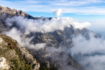 Panoramic view from Monte Comune on cloud covered peaks of Monte Molare, Canino, Caldare, Lattari Mountains, Apennines, Amalfi Coast, Italy, Europe. Hiking trail going to coastal town Positano at sea