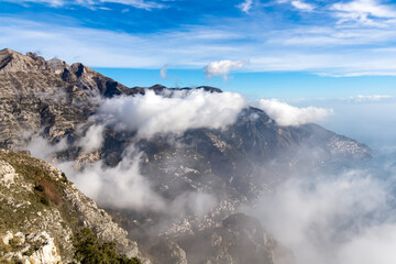 Panoramic view from Monte Comune on cloud covered peaks of Monte Molare, Canino, Caldare, Lattari Mountains, Apennines, Amalfi Coast, Italy, Europe. Hiking trail going to coastal town Positano at sea