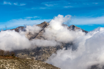 Panoramic view from Monte Comune on cloud covered peaks of Monte Molare, Canino, Caldare in Lattari Mountains, Apennines, Amalfi Coast, Italy, Europe. Hiking trail near the coastal town Positano.