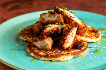 Closeup shot of a pancake with fried crispy chicken slices on a top